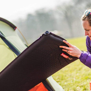Preparing a camping mat for sleeping on the snow