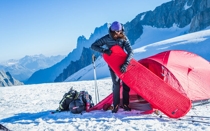 Preparing a camping mat for sleeping on the snow