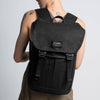 A female model is wearing the Trakke Bannoch Backpack in Black. The Bannoch is the COBRA variant